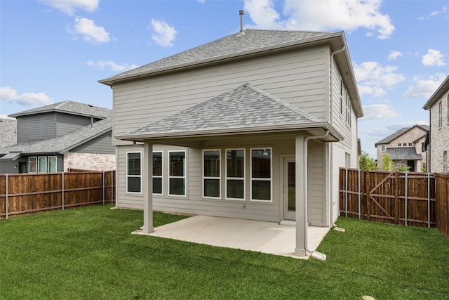 rear view of house featuring a lawn, roof with shingles, a fenced backyard, and a patio area