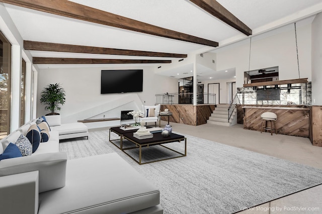 living area with a fireplace, carpet, beam ceiling, and recessed lighting