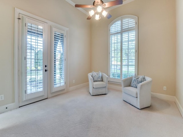 sitting room with baseboards, carpet flooring, ceiling fan, and crown molding