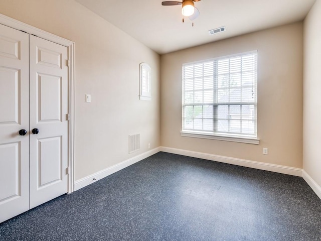 unfurnished room with baseboards, visible vents, and ceiling fan