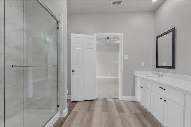 full bathroom with vanity, a shower stall, visible vents, a ceiling fan, and wood finished floors