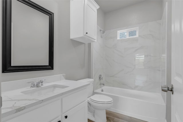 bathroom featuring wood finished floors, toilet, vanity, and washtub / shower combination