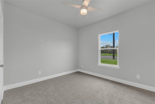 carpeted empty room with a ceiling fan and baseboards