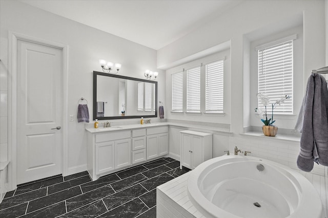 bathroom featuring double vanity, a sink, and a garden tub