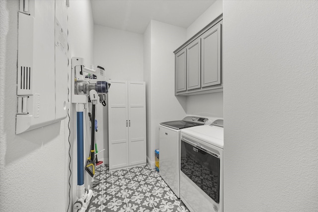 washroom featuring washing machine and clothes dryer, cabinet space, and light floors