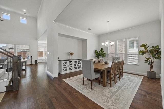dining space with a notable chandelier, baseboards, stairway, and wood finished floors