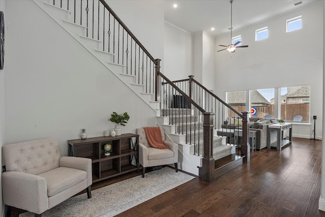 staircase with a wealth of natural light, wood finished floors, ceiling fan, and baseboards