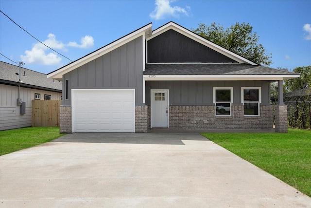 view of front of home with brick siding, a front yard, and driveway