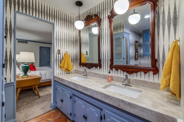 full bathroom with wallpapered walls, ensuite bathroom, a sink, and double vanity