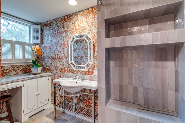 full bath with wallpapered walls and a sink