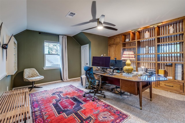 home office featuring carpet flooring, vaulted ceiling, visible vents, and ceiling fan