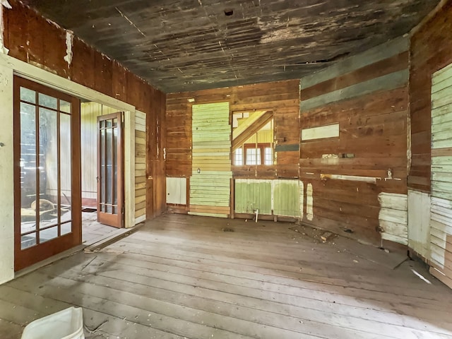 interior space featuring wooden walls, french doors, and hardwood / wood-style flooring