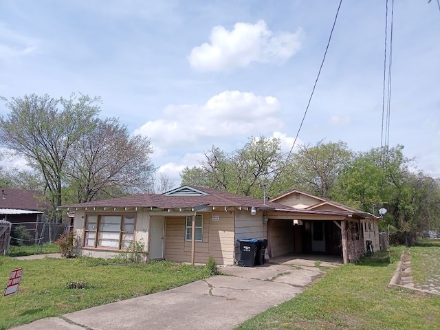 view of front of house featuring a front yard, concrete driveway, and fence
