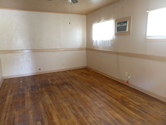 spare room featuring baseboards, a wall unit AC, ceiling fan, and hardwood / wood-style flooring