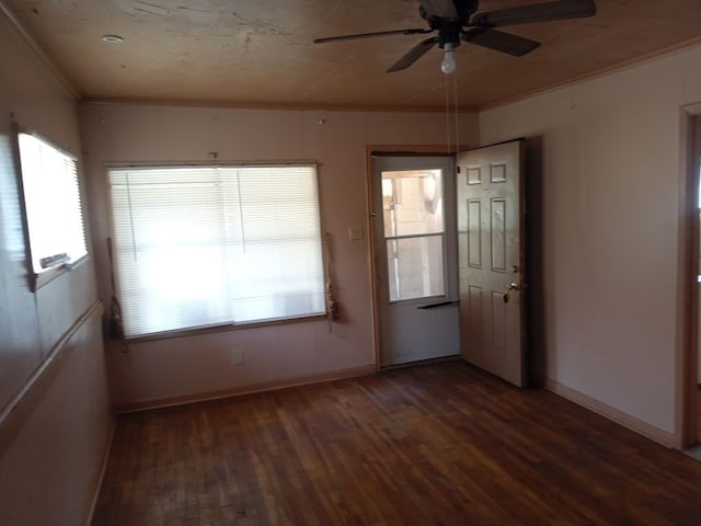 empty room featuring baseboards, ceiling fan, wood finished floors, and crown molding