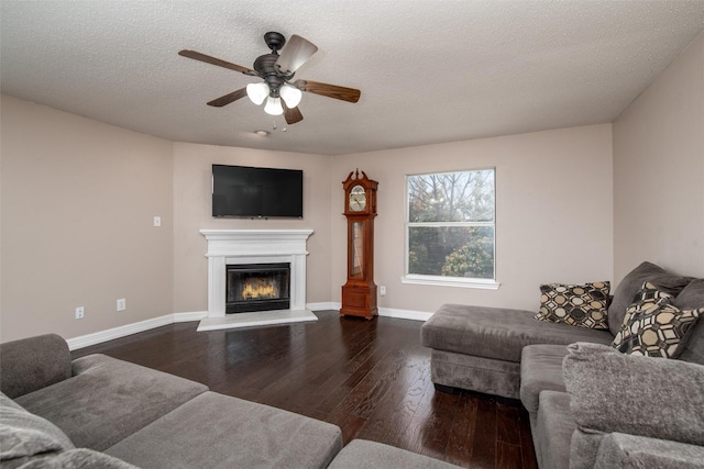 515 Meadow Dr, Lowry Crossing, TX 75069 - living room with a glass covered fireplace, ceiling fan, dark wood-style flooring, baseboards, and a textured ceiling