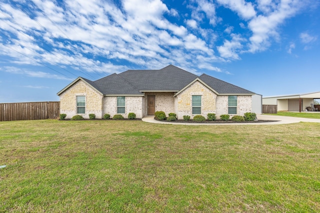 view of front of home featuring brick siding, fence, and a front yard