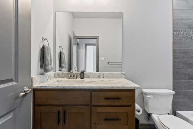 bathroom featuring toilet, vanity, a tub to relax in, and walk in shower