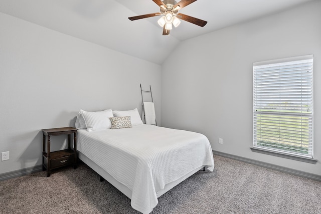 carpeted bedroom featuring baseboards, lofted ceiling, and a ceiling fan