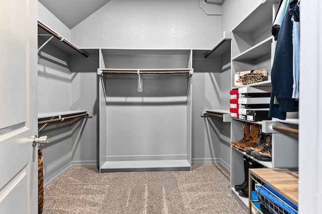 spacious closet with carpet floors and vaulted ceiling