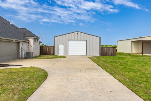 garage with cooling unit, concrete driveway, and fence
