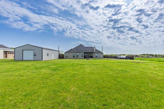 view of yard featuring an outbuilding, a garage, and fence