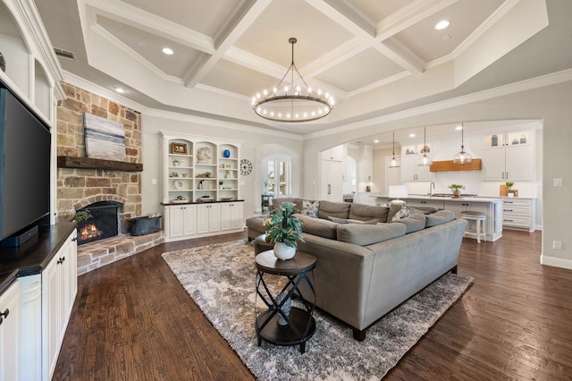 living area featuring visible vents, arched walkways, coffered ceiling, and ornamental molding