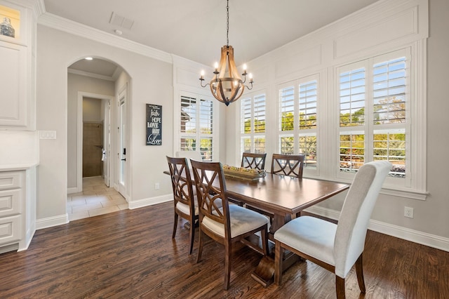 dining area featuring arched walkways, baseboards, a notable chandelier, and dark wood finished floors