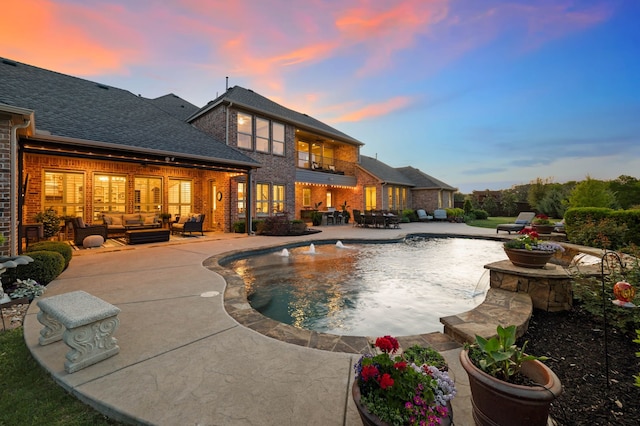 pool at dusk featuring a patio area, outdoor lounge area, and an outdoor pool