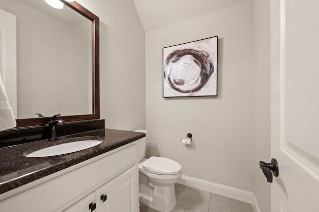 bathroom featuring vanity, baseboards, tile patterned floors, and toilet