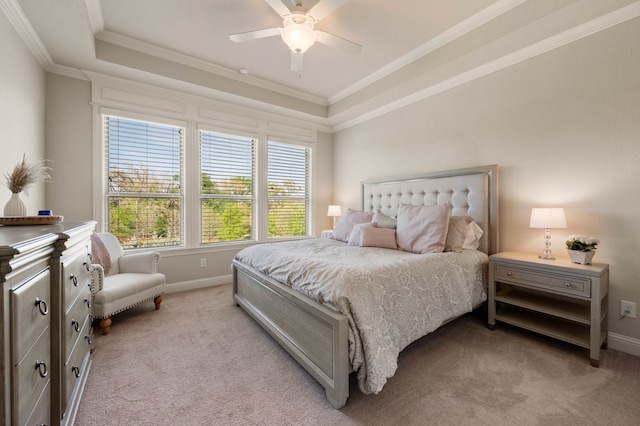 bedroom featuring a raised ceiling, ornamental molding, baseboards, and light colored carpet