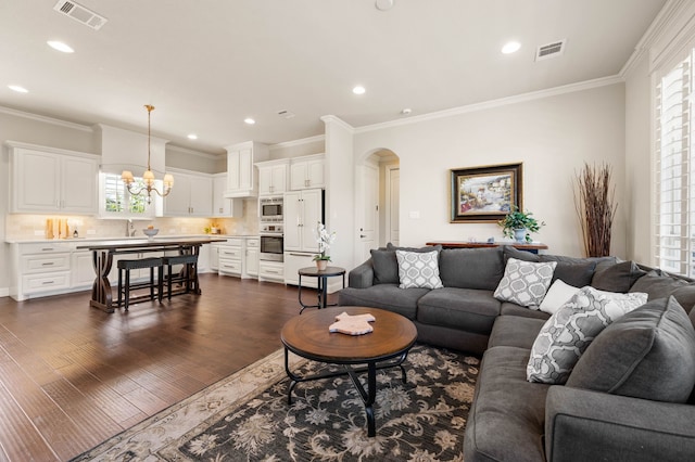 living area featuring a healthy amount of sunlight, arched walkways, and visible vents