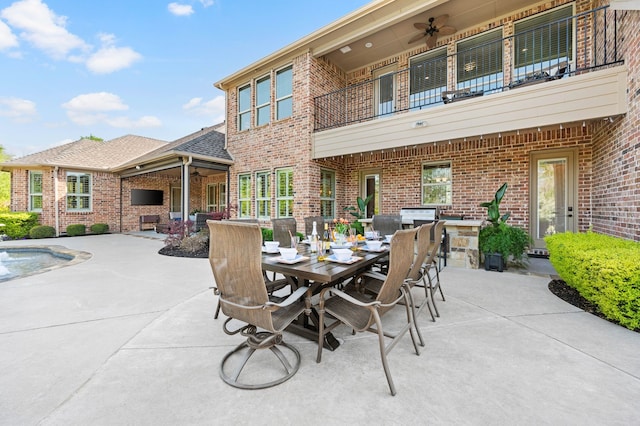 view of patio featuring outdoor dining area, a ceiling fan, and a balcony