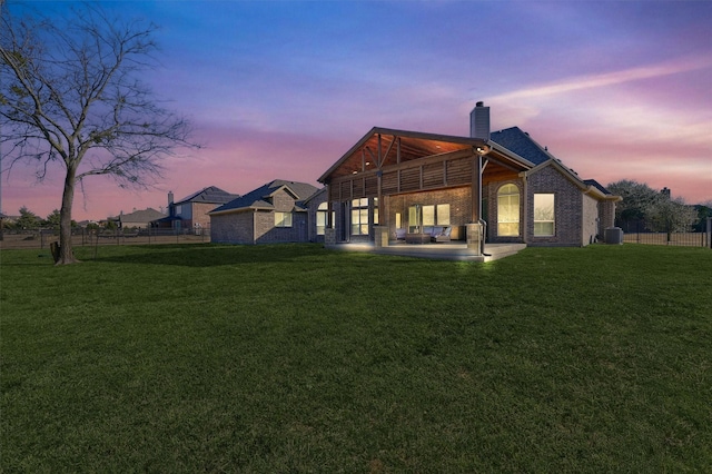 4994 Dogwood Dr, Celina, TX 75009 - back of house at dusk with a chimney, a patio, and brick siding