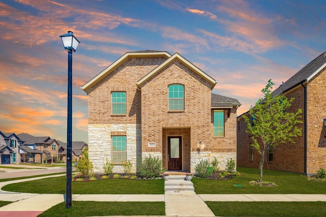 564 Embargo Dr, Fate, TX 75189 - traditional-style home featuring brick siding, a yard, and stone siding