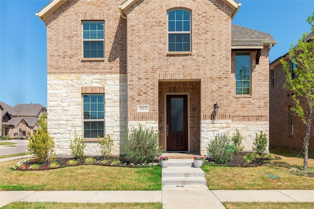 564 Embargo Dr, Fate, TX 75189 - traditional-style house featuring brick siding, stone siding, and a front yard