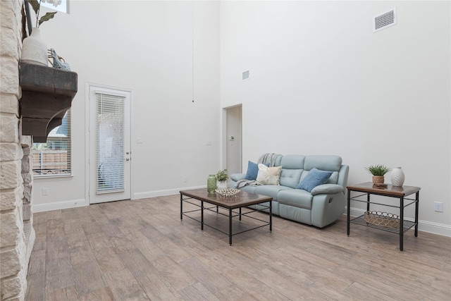 564 Embargo Dr, Fate, TX 75189 - living area featuring a towering ceiling, wood finished floors, visible vents, and baseboards