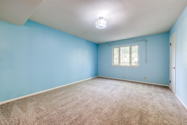 empty room with baseboards and carpet