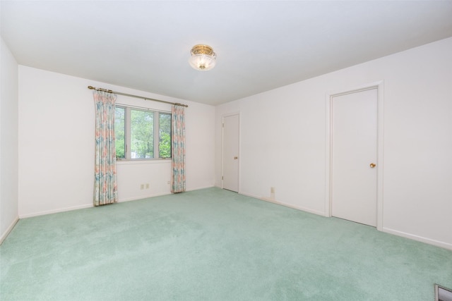empty room with baseboards and light colored carpet