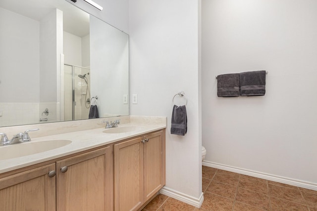 bathroom with tile patterned floors, double vanity, a stall shower, and a sink