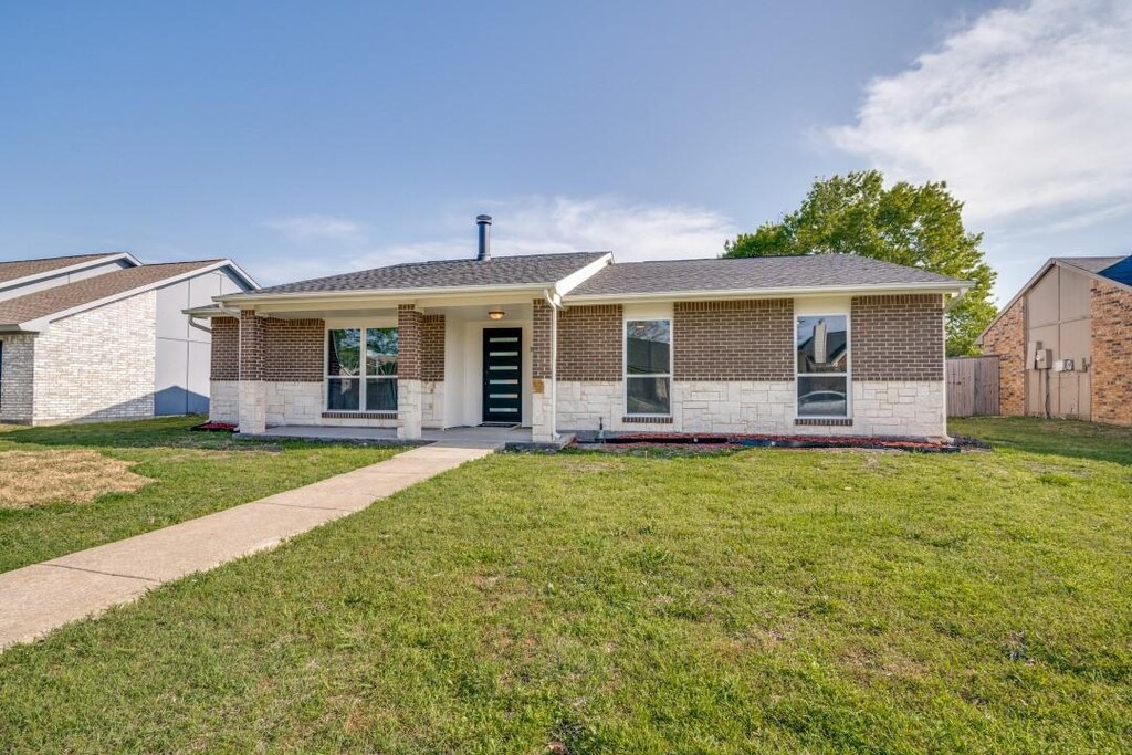 8102 Chesham Dr, Rowlett, TX 75088 - view of front of house featuring a front yard, stone siding, and brick siding