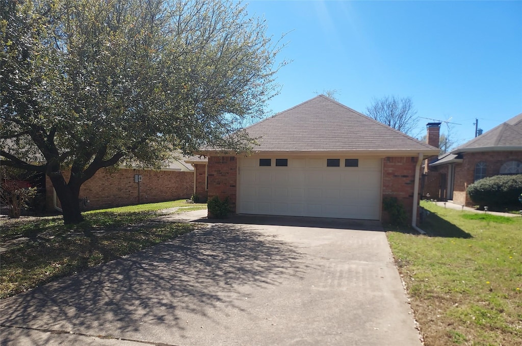 view of property exterior with driveway, brick siding, and a lawn