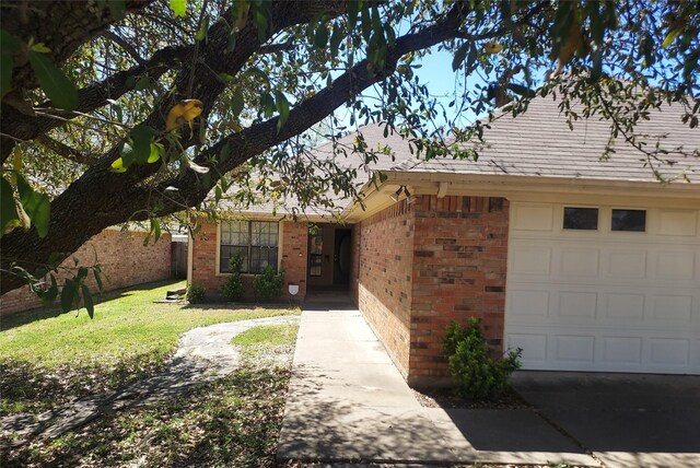 ranch-style house featuring brick siding, a garage, and a front lawn
