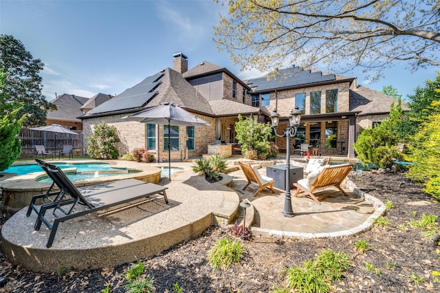 7201 Millard Pond Dr, Mckinney, TX 75071 - back of property with an outdoor hot tub, a patio, solar panels, and brick siding