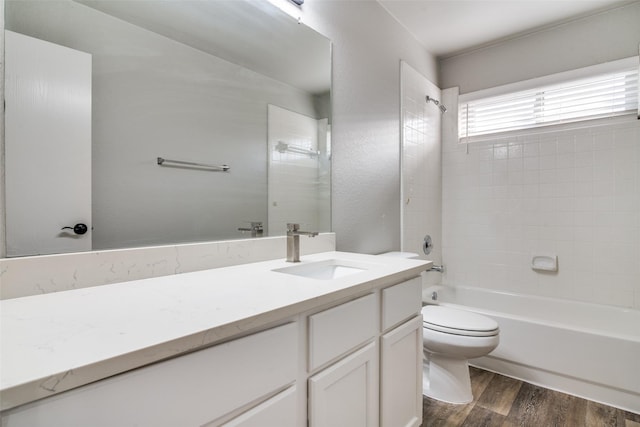 bathroom featuring toilet, shower / bath combination, wood finished floors, and vanity