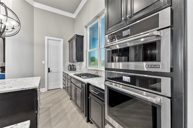 160 Pioneer Ct, Royse City, TX 75189 - kitchen featuring crown molding, light stone counters, decorative backsplash, light wood finished floors, and dark cabinetry