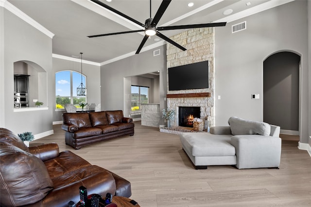 160 Pioneer Ct, Royse City, TX 75189 - living room with crown molding, arched walkways, ceiling fan, a stone fireplace, and baseboards