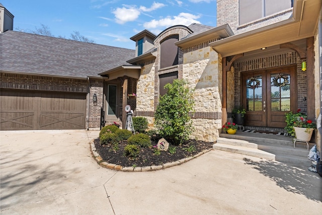 540 Prairie Timber Rd, Burleson, TX 76028 - property entrance featuring french doors, stone siding, driveway, a garage, and brick siding