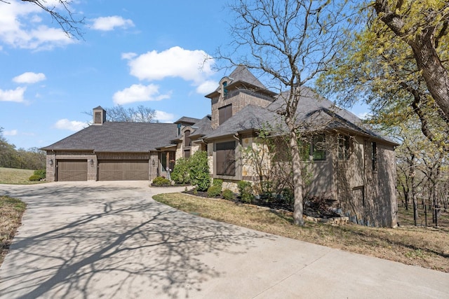 540 Prairie Timber Rd, Burleson, TX 76028 - view of front of house featuring driveway, a garage, stone siding, and a chimney