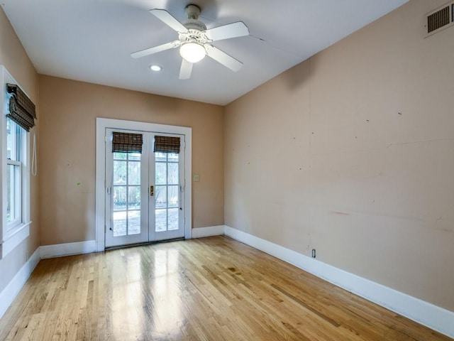 unfurnished room featuring light wood-type flooring, baseboards, and visible vents